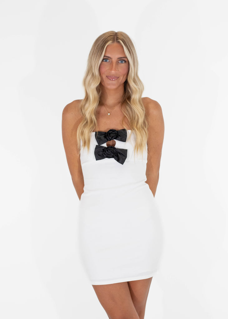 white strapless bodycon mini dress with two black bows on chest