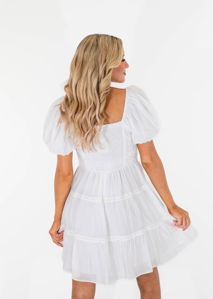 white flowy mini dress with a tiered design and puff sleeves