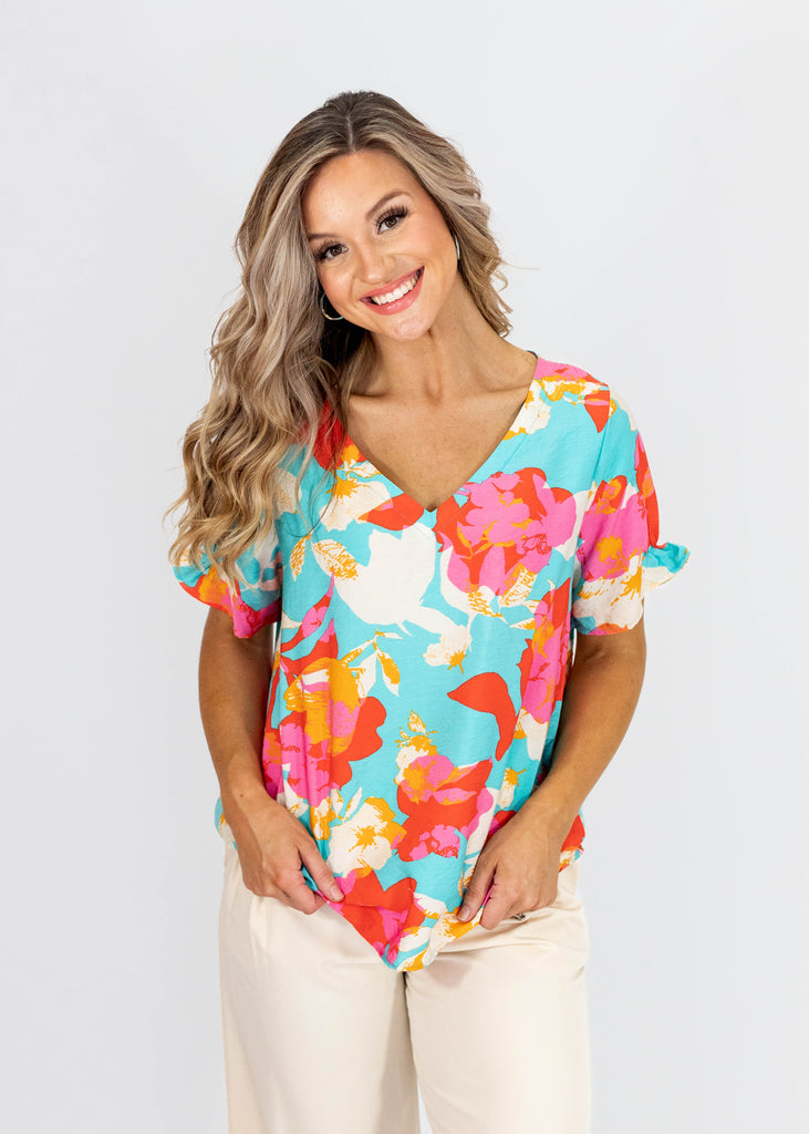 blue v-neck top with red/pink/white floral print and frilly sleeve hem